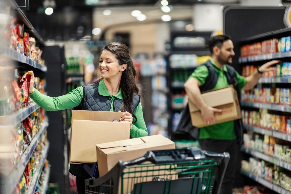 Happy,Employees,Putting,Products,On,Shelves,In,Supermarket.
