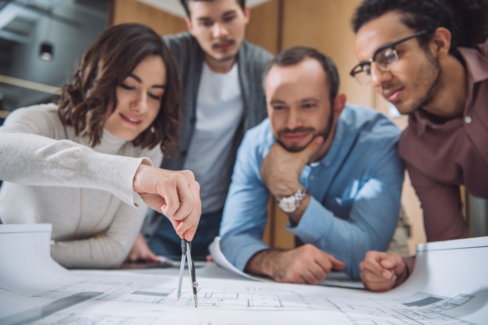 Close-up,Shot,Of,Group,Of,Architects,Drawing,Building,Plan,Together